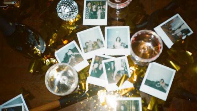A nostalgic collection of instant photos amidst a festive party scene with wine glasses and disco decor.