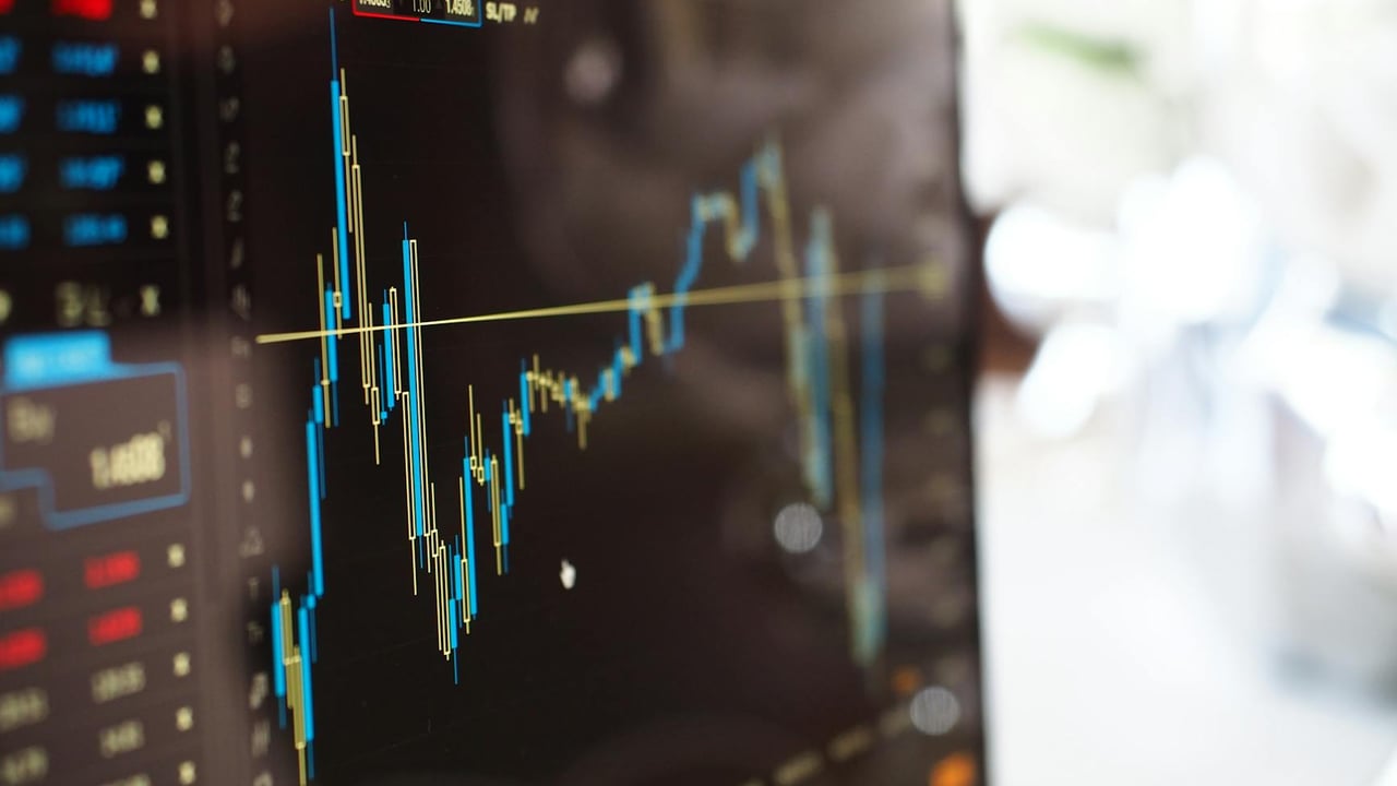 Detailed view of financial trading graphs on a monitor, illustrating stock market trends.