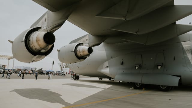 Close-up of a C-17 aircraft's engines and wings on an airstrip, showing its massive structure.