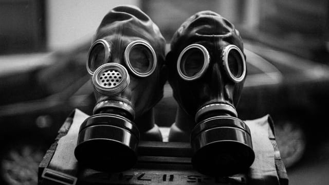Close-up of two gas masks in black and white, emphasizing protection and preparedness.