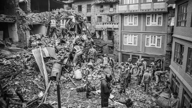 Rescue operations amidst earthquake destruction in Bhaktapur, Nepal. Soldiers sift through rubble.