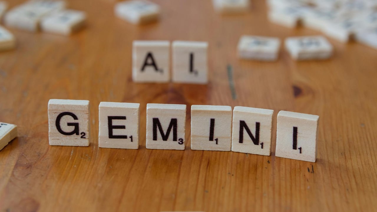 Scrabble tiles spell out the words 'Gemini' and 'AI' on a wooden surface, symbolizing technology and communication.