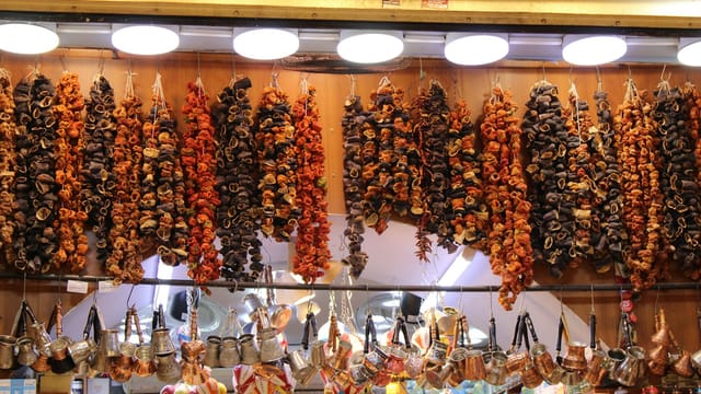 Vibrant strings of dried vegetables in a traditional market stall setting.