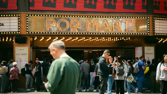 A lively crowd gathers outside the Pop Mart entrance in Taiwan, showcasing vibrant city life and activity.