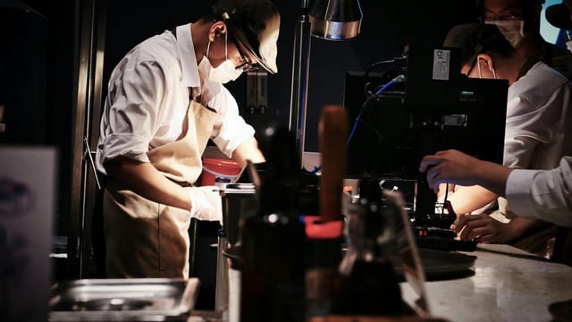 Chefs in a busy restaurant kitchen preparing dishes with precision and teamwork.