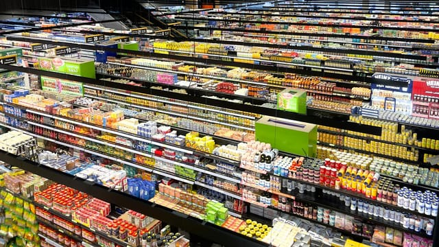 Aerial view of supermarket aisles filled with colorful products and packaging.