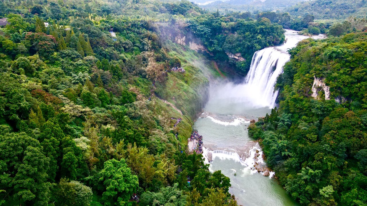 Stunning aerial view of Lushui Waterfall surrounded by lush forest in Zunyi, Guizhou Province, China.