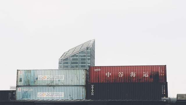 Urban scene of stacked shipping containers with modern architecture background in Tianjin, China.