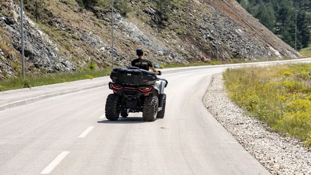 A quad biker enjoys a scenic ride on a winding mountain road in Zlatibor, Serbia.