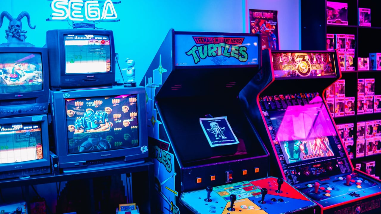 A vibrant retro arcade room featuring classic gaming machines and colorful neon lighting.