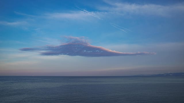 Tranquil view of a pink cloud above the calm sea near Tekirdağ, Türkiye at twilight.