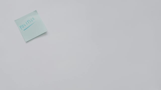 A simple sticky note with 'politics' written on it, offering ample copyspace.