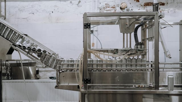 Automated beverage can packaging in a modern factory setting.