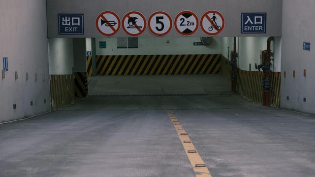 Entrance to underground parking with clear prohibition signs and exit markings.
