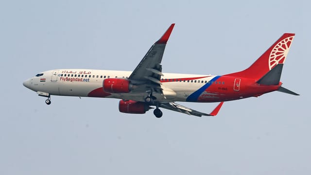 Boeing 737 of Fly Baghdad airlines captured mid-flight with landing gear visible.