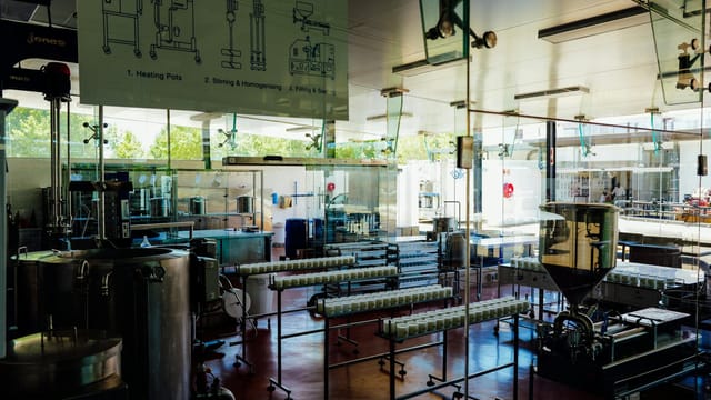 Spacious and modern food production plant interior with industrial machinery and processing line.