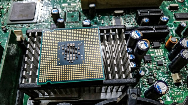Detailed view of a CPU on a motherboard showcasing electronic components and circuitry.