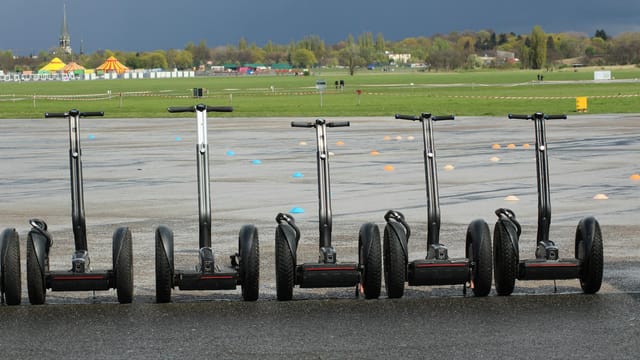 Line of Segways parked on pavement at an open space event in Berlin.