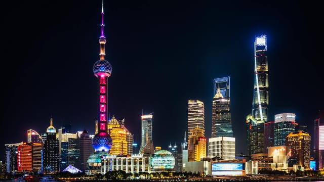 Vibrant night view of Shanghai's illuminated skyline featuring the iconic Oriental Pearl Tower.