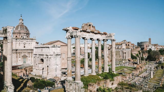 View of the historic ruins of the Roman Forum in Rome, Italy on a sunny day.