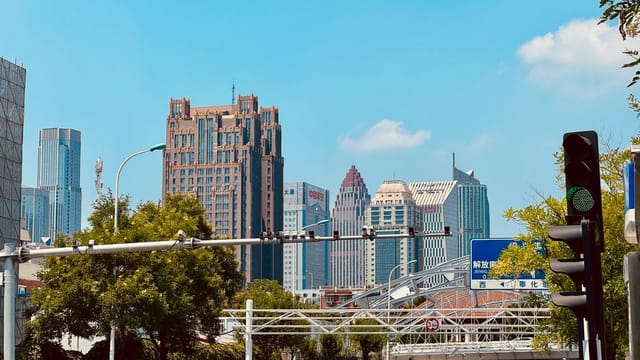 A vibrant cityscape of downtown Tianjin showcasing modern skyscrapers under a clear blue sky.