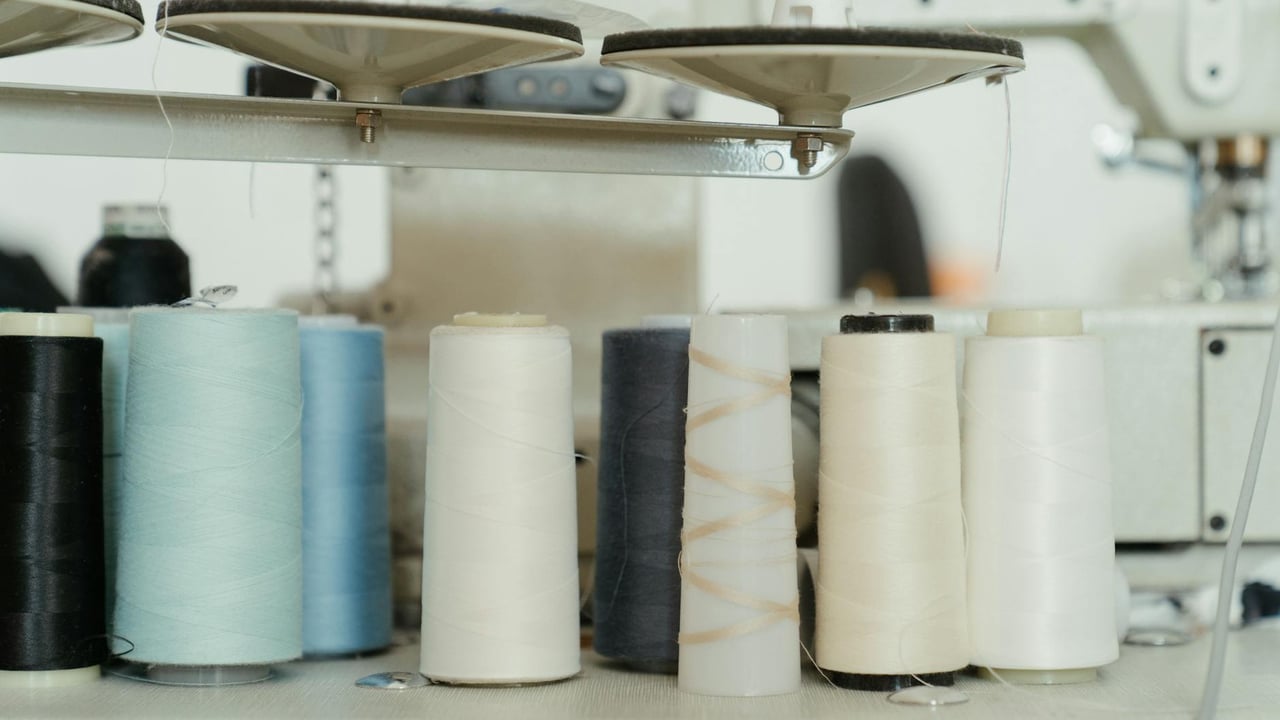 A variety of colorful thread spools on a sewing machine in a workshop setting.
