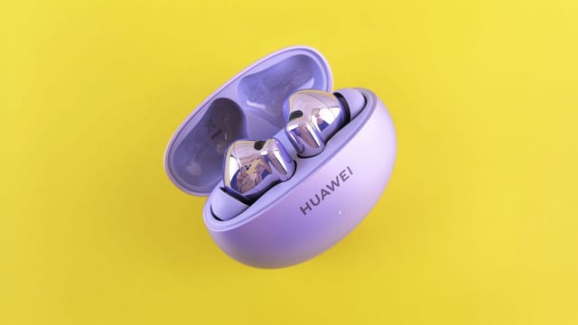 Modern purple earbuds in a case on vibrant yellow background.