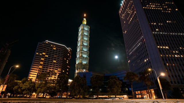 Stunning night view of Taipei 101 surrounded by city lights and skyscrapers.