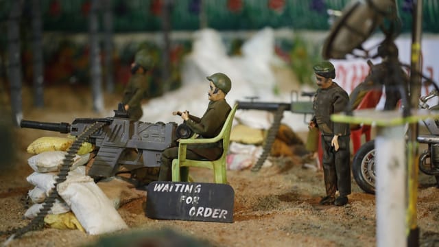 Detailed diorama featuring miniature toy soldiers in a military scene, depicting wartime activities.