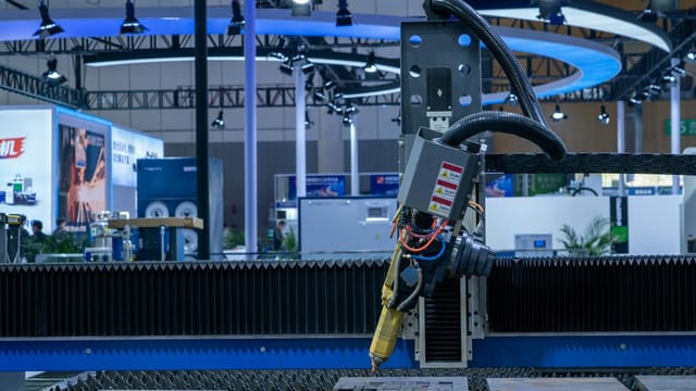 A CNC laser machine operating in a high-tech industrial exhibition setup with vibrant lighting.