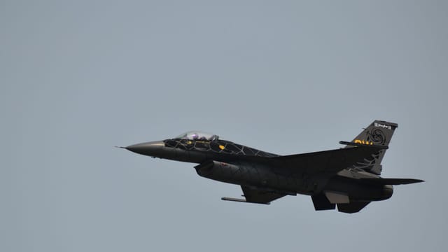 A powerful military fighter jet flying high against a clear sky, showcasing aviation excellence.