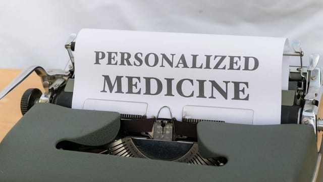 An old-fashioned typewriter displaying a paper with 'Personalized Medicine' text, emphasizing custom healthcare.