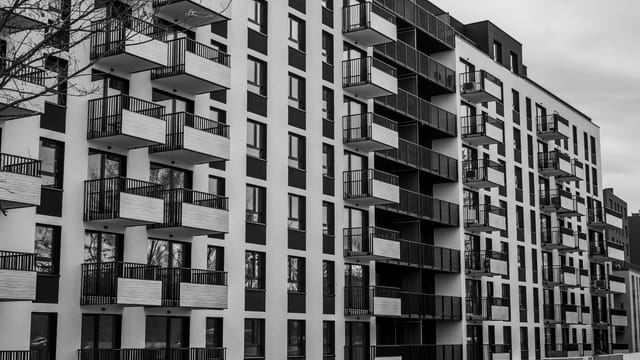 Black and white photo of a contemporary apartment building with multiple balconies.