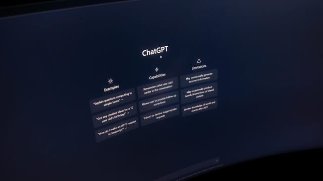Close-up of a computer screen displaying ChatGPT interface in a dark setting.