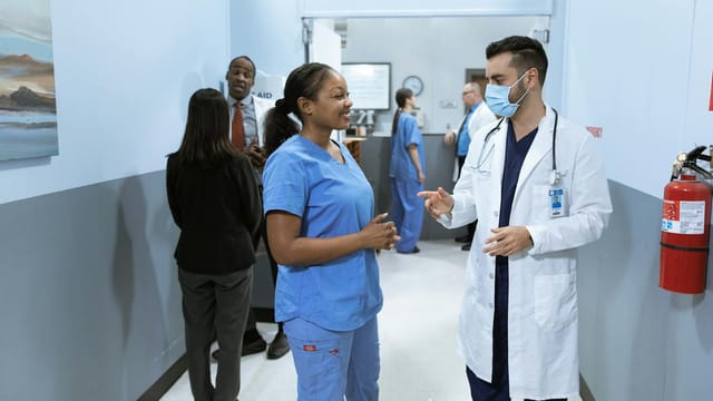 Doctors and nurses in a hospital hallway discussing medical matters.
