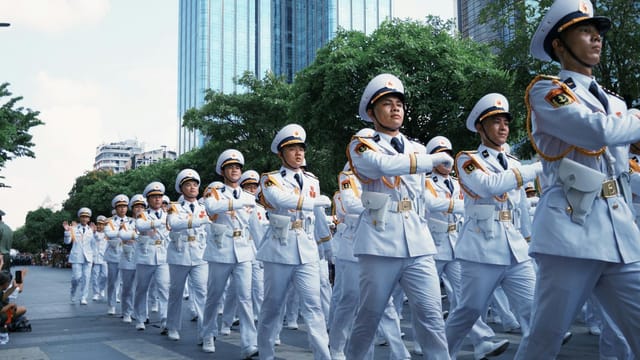 Group of uniformed officers marching in a city parade.