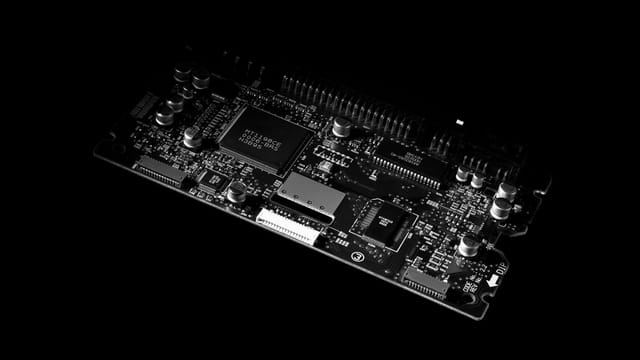 Detailed black and white image of a computer circuit board, showcasing technology components.