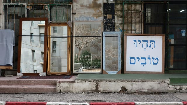 Decorative mirrors displayed outdoors in an Israeli street setting, adding a unique urban charm.