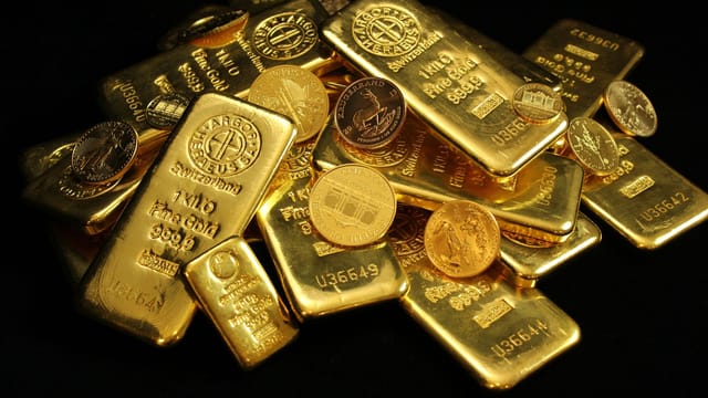 A collection of shining gold bars and coins symbolizing wealth and investment.