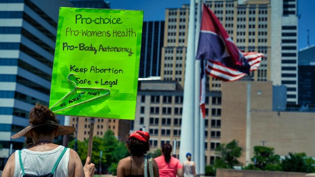 Women’s rights rally with pro-choice placards in a city square, highlighting activism.
