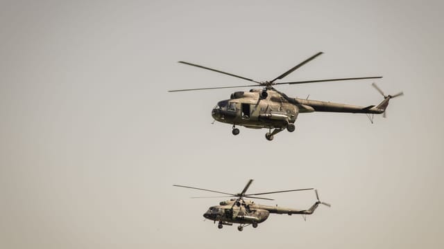 Two military helicopters flying at low altitude in clear sky over Beograd, Serbia.