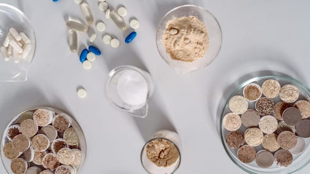High-angle shot of various pharmaceutical ingredients and pills on a white surface. Ideal for healthcare and science themes.