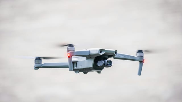 A sleek drone flies through the sky, showcasing modern aerial technology.