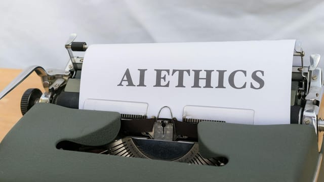 Close-up of vintage typewriter with 'AI ETHICS' typed on paper, emphasizing technology and responsibility.