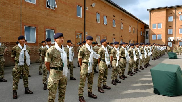 Gurkha soldiers stand in formation at Catterick Garrison, England, showcasing discipline and unity.