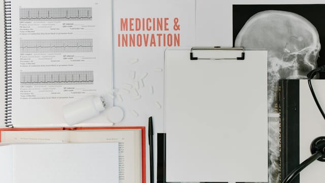 Flat lay of medical documents and equipment emphasizing innovation.