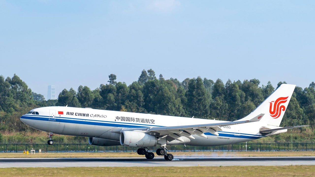 Air China Cargo aircraft lifting off against a clear blue sky at an airport.