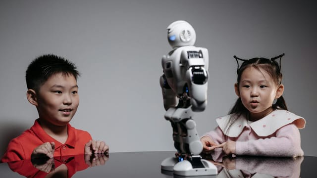 Kids amazed by a humanoid robot during an indoor play session, showcasing technology and learning.