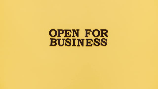 Bold 'Open for Business' text on a vibrant yellow background for advertising.
