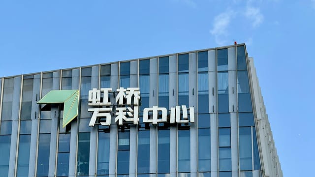 A modern office building with Chinese signage under a clear blue sky.